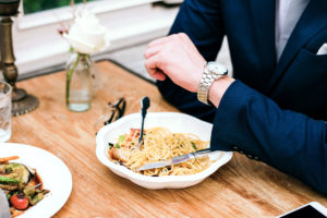 Intermitent Fasting 101 - person looking at the watch with a food in from of him